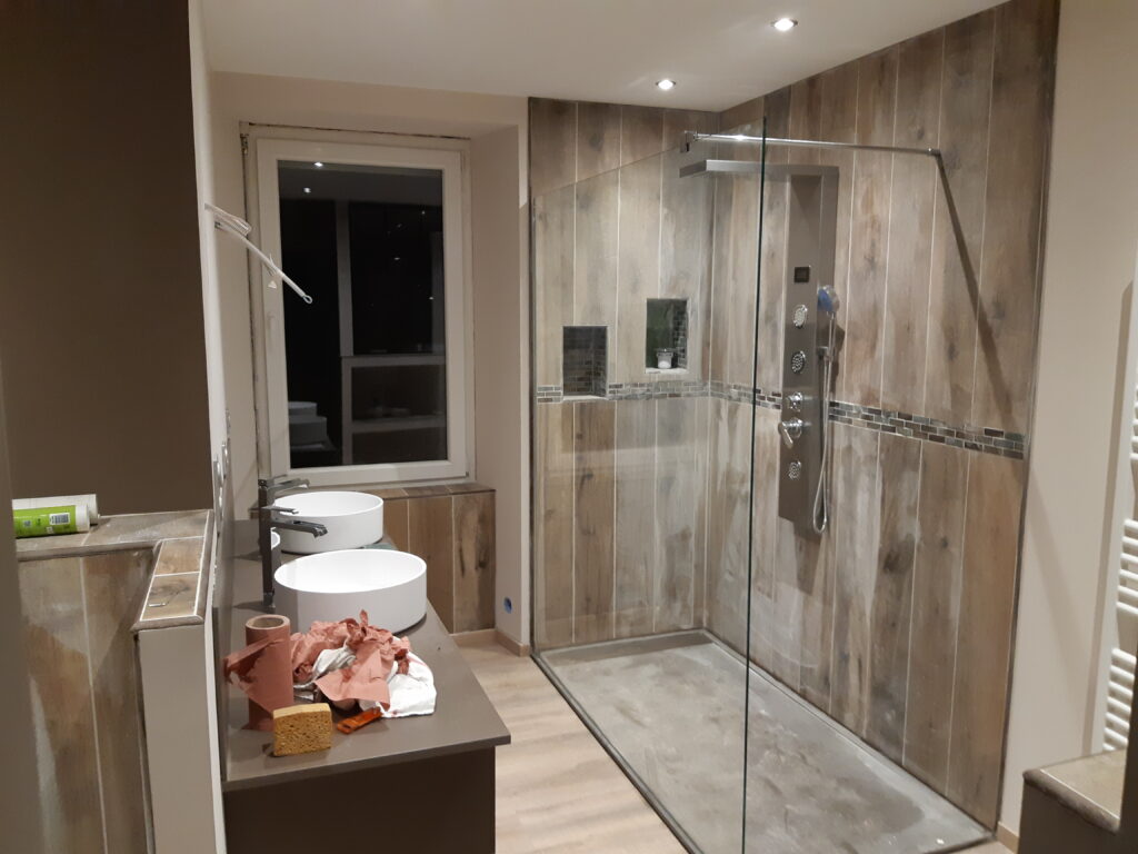 Salle de bains réalisée par VZCR, carrelage aspect bois, douche italienne, meuble double vasque.