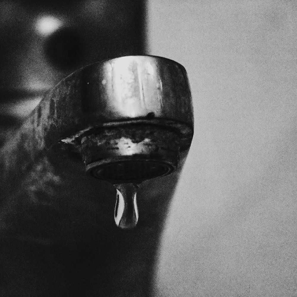 Robinet en noir et blanc qui fait du goutte à goutte